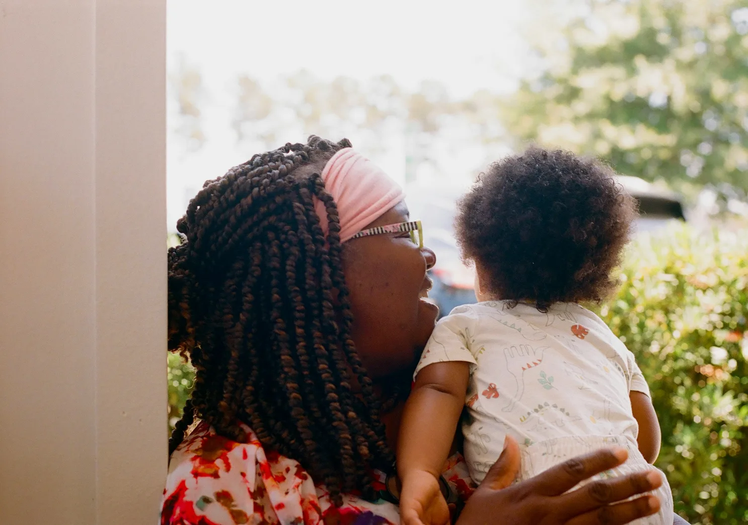 Mother holding her baby near a window.